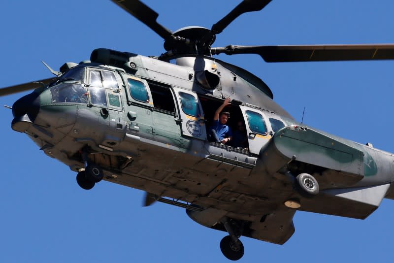 Brazil's President Jair Bolsonaro gestures from a helicopter flying over the Planalto Palace during a protest in his favor, amid the coronavirus disease (COVID-19) outbreak, in Brasilia