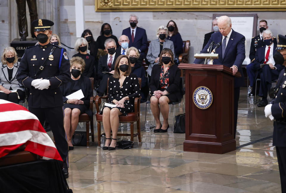 President Joe Biden speaks near the casket of former Sen. Bob Dole, who died on Sunday, during a congressional ceremony to honor Dole, who lies in state in the U.S. Capitol Rotunda in Washington, Thursday, Dec. 9, 2021. At left are Elizabeth Dole and their daughter Robin Dole. (Jonathan Ernst/Pool via AP)