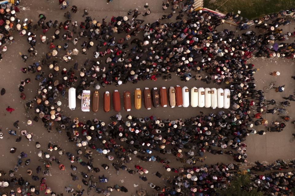 ARCHIVO - Los residentes rodean los ataúdes durante una vigilia por las más de una docena de personas que murieron durante los disturbios en Juliaca, Perú, el martes 10 de enero de 2023. Grupos de derechos humanos, incluida la ONU, han pedido al gobierno peruano que investigue denuncias de uso excesivo de la fuerza por parte de policías y soldados durante las recientes protestas que han dejado 49 civiles muertos. (AP Foto/Jose Sotomayor, Archivo)