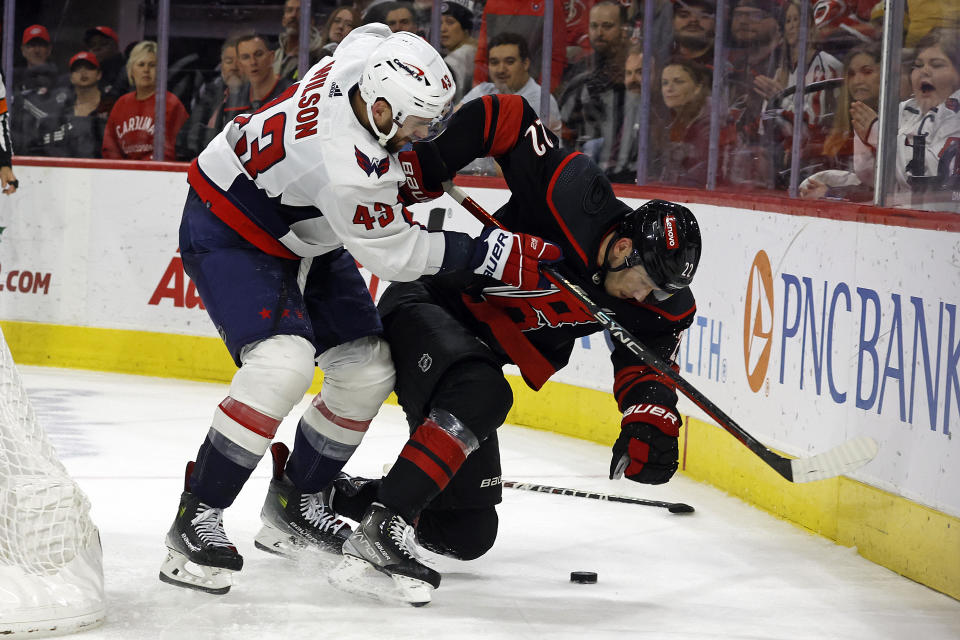 Washington Capitals' Martin Fehervary (42) battles with Carolina Hurricanes' Brett Pesce (22) during the third period of an NHL hockey game in Raleigh, N.C., Sunday, Dec. 17, 2023. (AP Photo/Karl B DeBlaker)