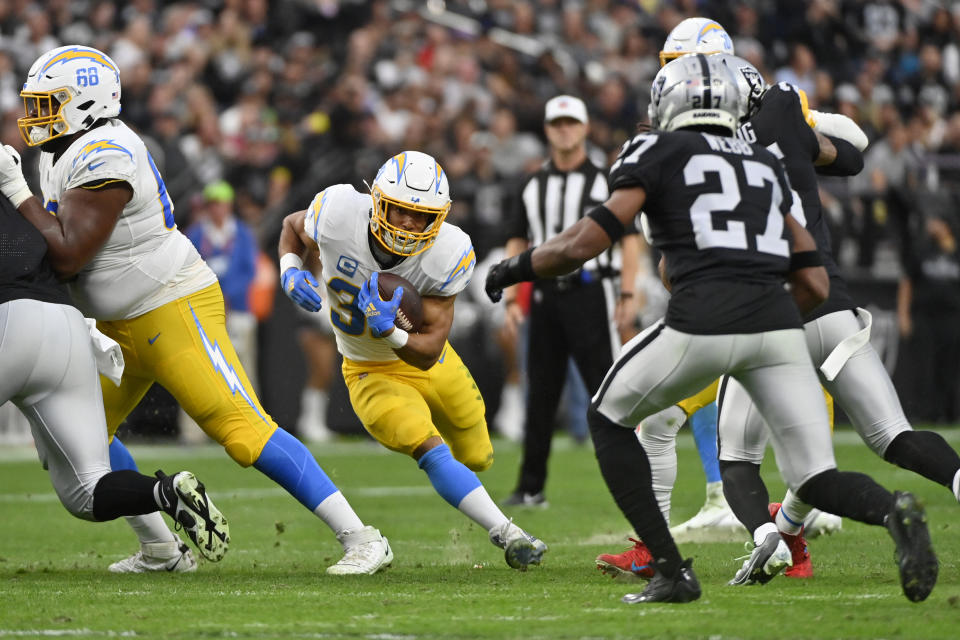 Los Angeles Chargers running back Austin Ekeler (30) carries for a first down during the first half of an NFL football game against the Las Vegas Raiders, Sunday, Dec. 4, 2022, in Las Vegas. (AP Photo/David Becker)