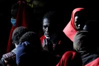 Migrants wait to disembark from a Spanish coast guard vessel, in the port of Arguineguin