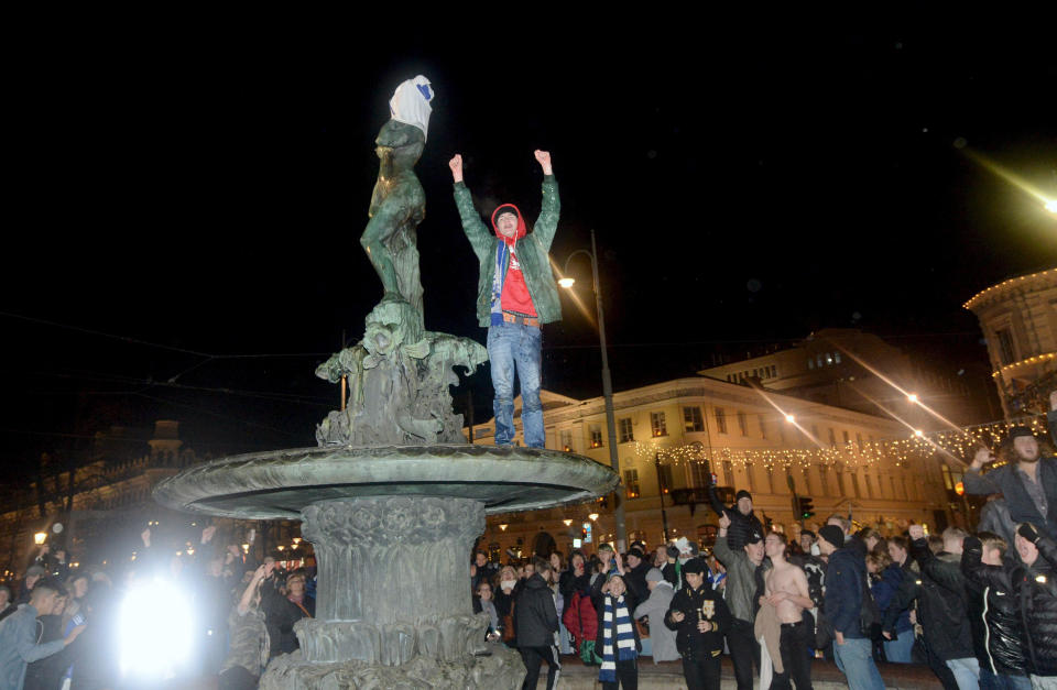 Finnish Fans celebrate victory at a covered fountain in central Helsinki, Friday, Nov. 15, 2019, after the Euro 2020 Group J qualification football match between Finland and Liechtenstein. Finland won 3-0 and have qualified for a major soccer tournament for the first time in their history. (Martti Kainuleinen/Lehtikuva via AP)