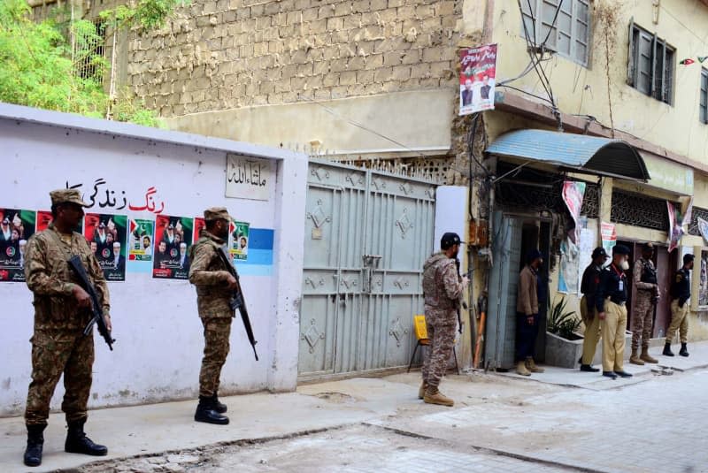 Security officials stand outside a polling station during the 2024 Pakistani general election. -/PPI via ZUMA Press Wire/dpa
