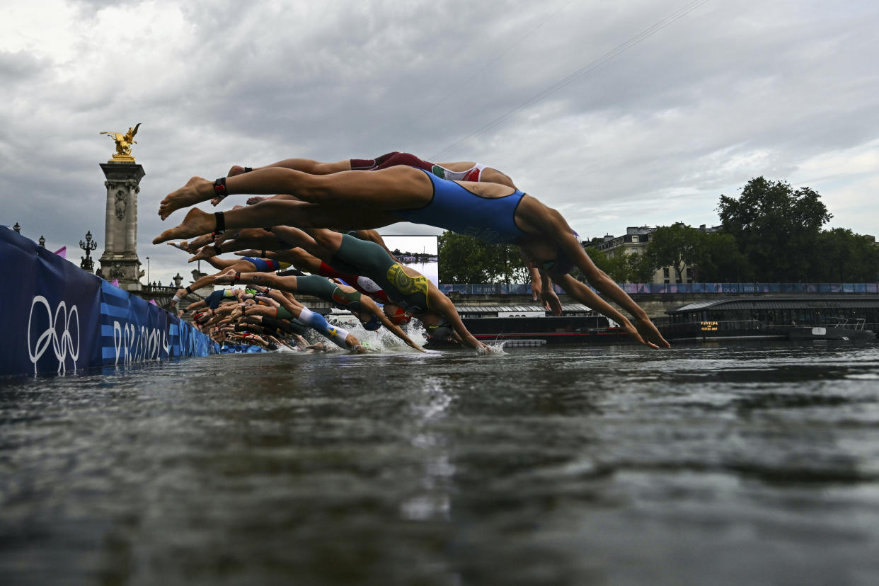 Atletas comienzan a nadar en el río Sena para la competencia de triatlón. (Martin Bureau/Pool Photo via AP)