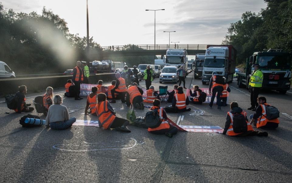 The protesters from Insulate Britain sit down in the middle of the carriageway - Guy Smallman/Getty