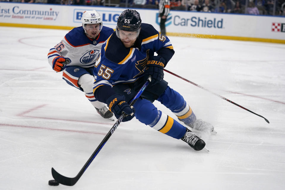 St. Louis Blues' Colton Parayko (55) controls the puck as Edmonton Oilers' Kailer Yamamoto (56) watches during the third period of an NHL hockey game Wednesday, Oct. 26, 2022, in St. Louis. (AP Photo/Jeff Roberson)