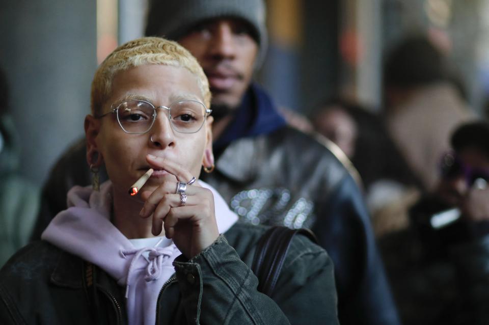 A person smokes weed while waiting in line during the opening of the first legal cannabis dispensary in New York City on December 29, 2022 following legalization. (Photo by KENA BETANCUR/AFP)