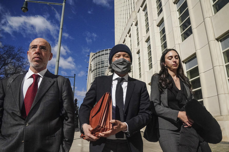 Roger Ng, center, a former Goldman Sachs banker, leaves federal court with his lawyers Zach Intrater, left, and Teny Geragos, right, after being sentenced to 10 years in prison for his role in looting a Malaysian development fund, Thursday March 9, 2023, in New York. (AP Photo/Bebeto Matthews)
