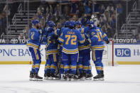 St. Louis Blues' Ryan O'Reilly (90) is congratulated by teammates after scoring the winning goal against the Minnesota Wild during overtime of an NHL hockey game on Saturday, April 10, 2021, in St. Louis. (AP Photo/Joe Puetz)