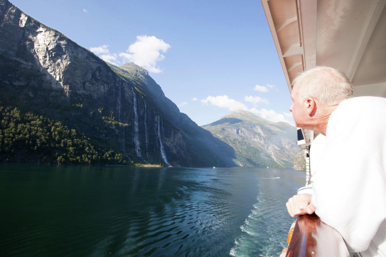 Man admiring view of the Seven Sisters Falls in Geirangerfjord Norway