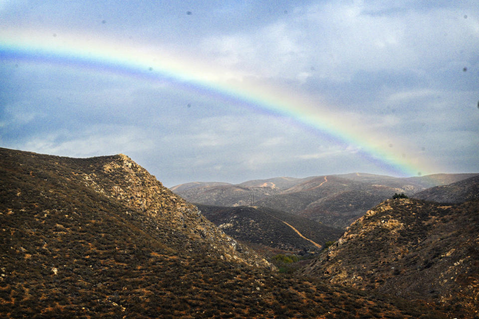 A rainbow appears over the Cajalco hills near Corona, Calif., on cloudy and slightly rainy Tuesday, Dec. 19, 2023. (Anjali Sharif-Paul/The Orange County Register via AP)