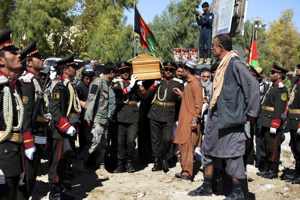 Guards of honor carry the coffin of Gen. Abdul Raziq, Kandahar police chief, who was killed by a guard, during his burial ceremony in Kandahar, Afghanistan, Friday, Oct. 19, 2018. Afghanistan's election commission on Friday postponed elections in Kandahar for a week, following a brazen attack on a high-profile security meeting there with a U.S. delegation that killed at least two senior provincial officials, including the province's police chief. (AP Photo)