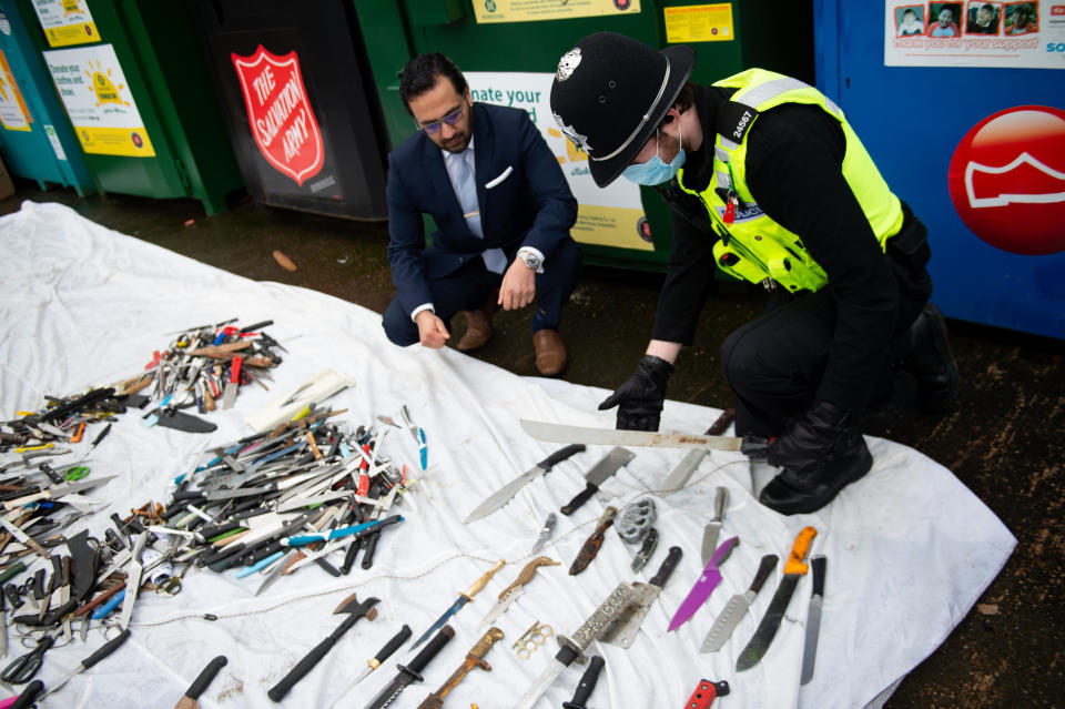 <p>West Midlands Deputy Police and Crime Commissioner, Waheed Saleem and a police officer showing the knives and other weapons that have been deposited into weapon surrender bins at Morrisons in Bilston, Wolverhampton. Picture date: Friday March 19, 2021.</p>
