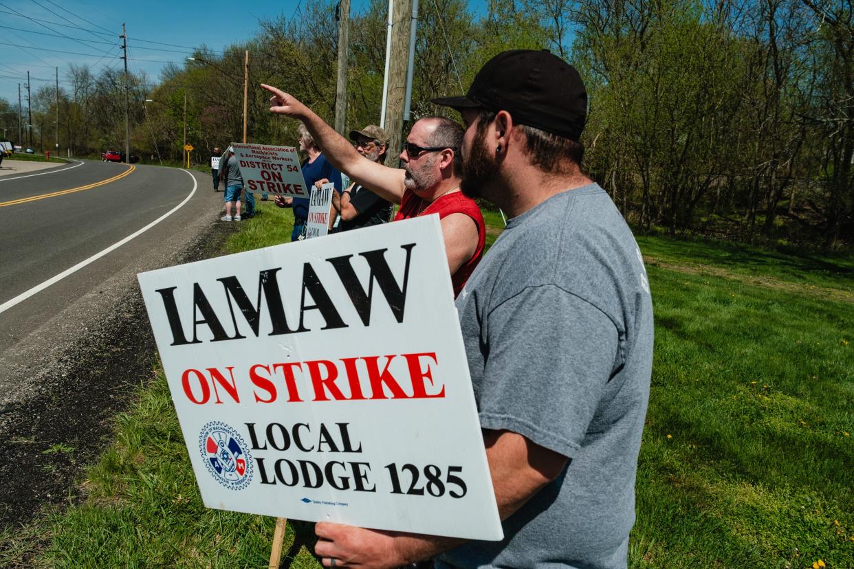 Striking members of the International Association of Machinists and Aerospace Workers Local 1285, employed by Gradall Industries, Inc., gesture to passing motorist offering support while picketing across the street from Gradall, April 15, in New Philadelphia.