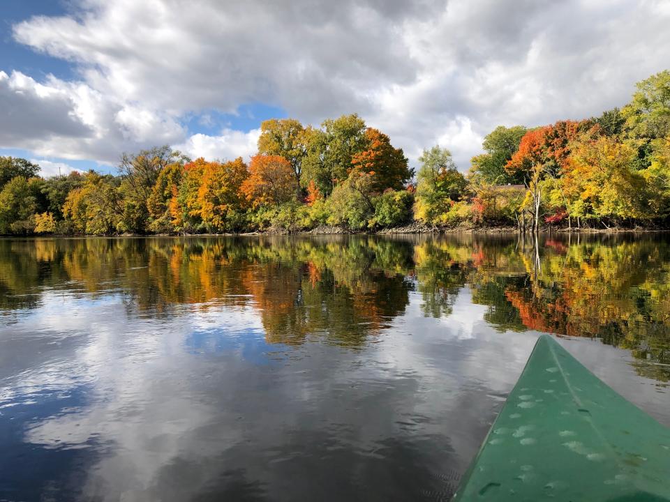 Fall colors reflect in the St. Joseph River in South Bend, seen from a kayak Oct. 16, 2022.