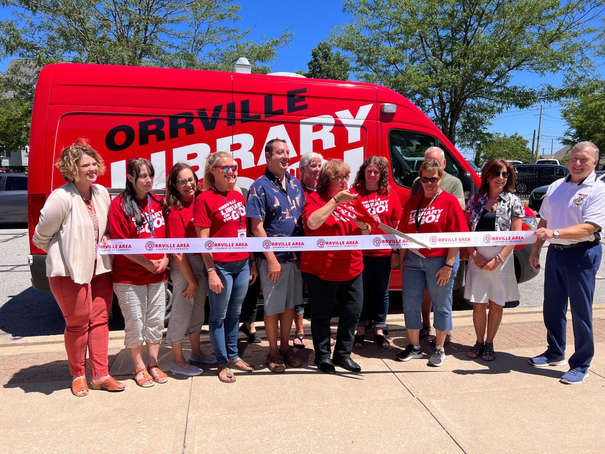 On hand to kick off the Library on the Go initiative at the Orrville Public Library on Thursday were Lori Reinbolt (left), Wendy Ensor, Tammy Daubner, Jenny McFarren, Amy Spinelli, Shane Scarbrough, Lisa Joyce, Daphne Silchuk-Ashcraft, Corrie Yoder, Denise Odenkirk, Rich Thomas, Michelle Hedberg and Mayor Dave Handwerk.