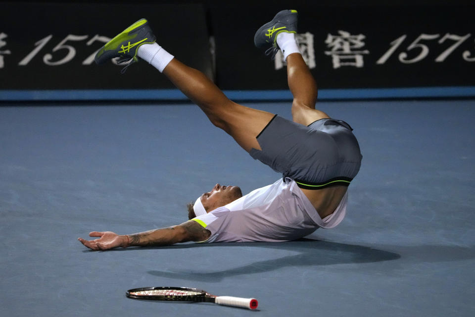 Alex Molcan of Slovakia falls onto the court after defeating Stan Wawrinka of Switzerland in their first round match at the Australian Open tennis championship in Melbourne, Australia, Monday, Jan. 16, 2023. (AP Photo/Ng Han Guan)