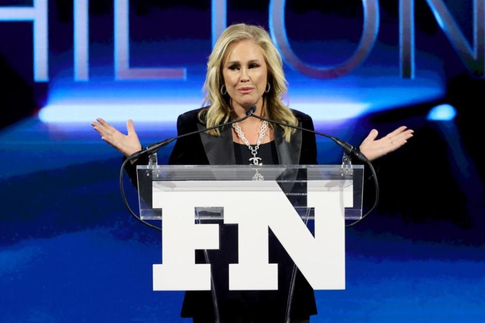 Kathy Hilton onstage accepting the Icon Award with daughters Nicky and Paris at the 2021 FNAAs. - Credit: Getty