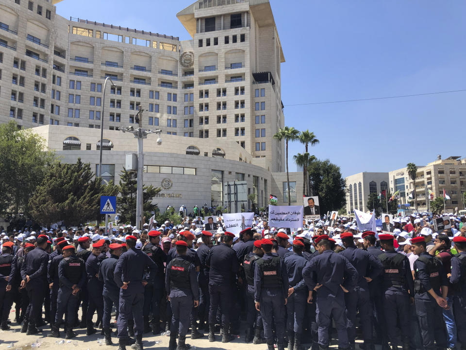 FILE - In this Sept. 5, 2019 file photo, security forces block a road as teachers protest in Amman, Jordan. The kingdom has become more repressive, with a U.S. advocacy group downgrading it from “partly free” to “not free” this year. The economy continues to decline and public trust in the ruling Hashemite dynasty has been undermined by a pair of royal scandals. (AP Photo/Omar Akour, File)