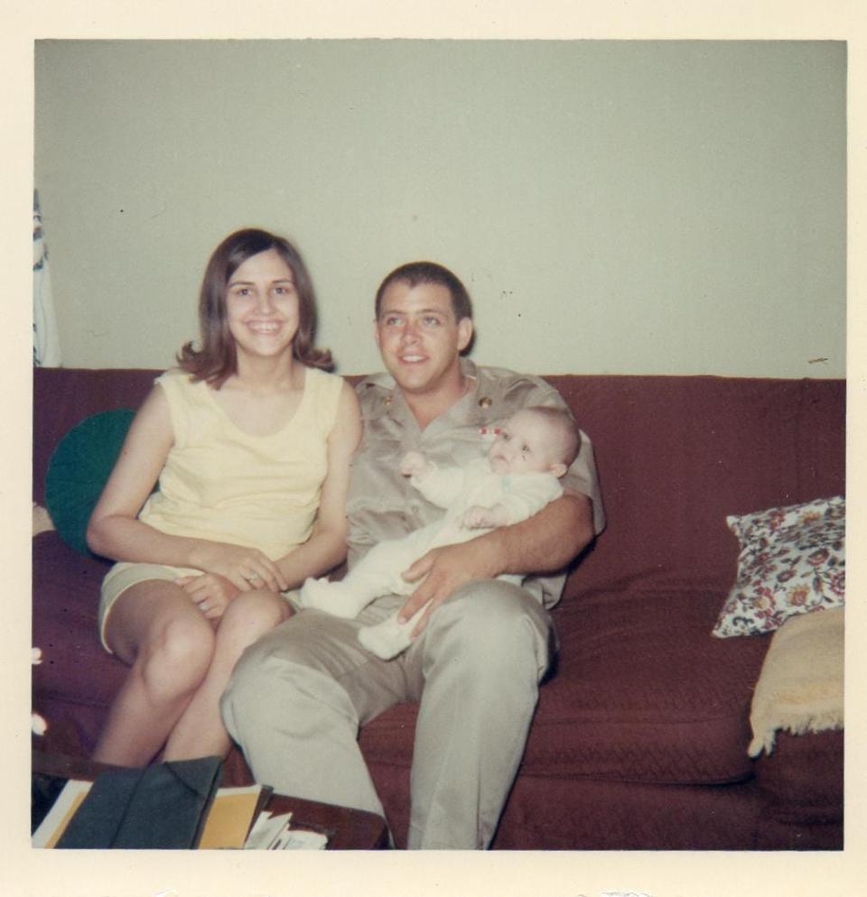 Dick sits with his wife, Sue, and baby son, Brian, at home in Princeton.