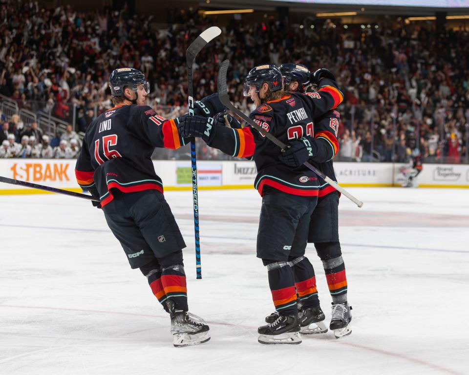 Ville Petman (#33) celebrates with teammate Kole Lind (#16) after scoring a goal during the AHL Calder Cup Finals game between the Coachella Valley Firebirds and the Hershey Bears at Acrisure Arena in Palm Desert, CA on June 8, 2023