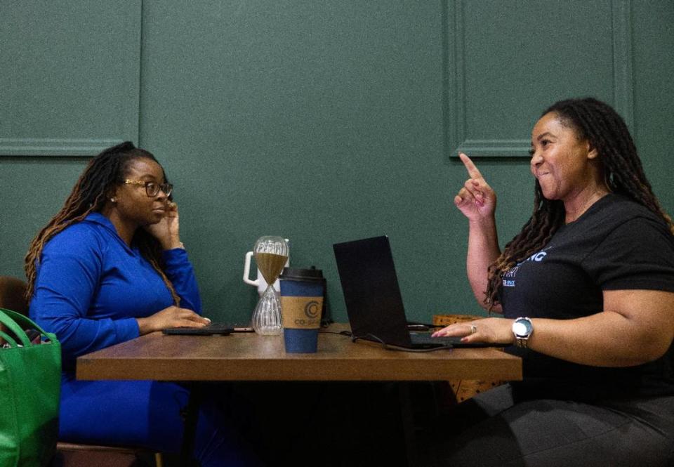 Joy St. Clair, founder of Co-Space, right, talks to someone while working at a table with her sister, Ashley Carter, on Thursday, Jan. 11, 2024, in Miami Gardens. St. Clair said it’s the first coworking space in the area. Alie Skowronski/askowronski@miamiherald.com