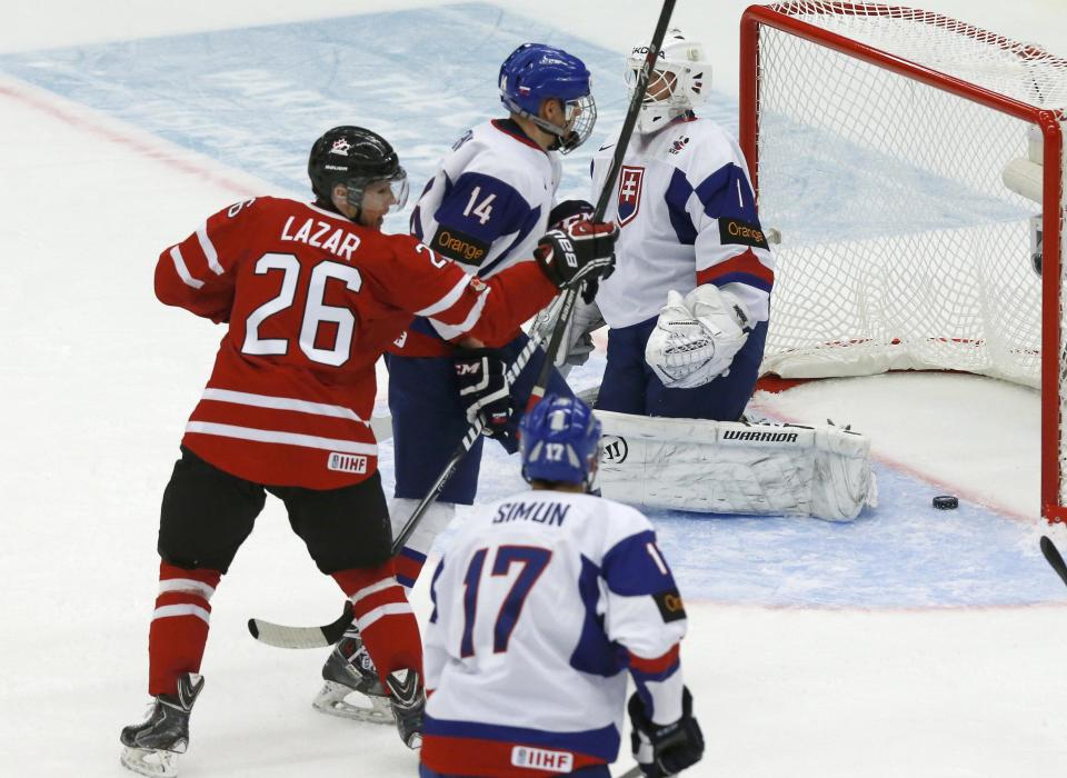 Canada's Curtis Lazar (26) reacts after scoring on Slovakia's goalie Samuel Baros in front of Slovakia's Eduard Simun (17) and David Griger (14) during the first period of their IIHF World Junior Championship ice hockey game in Malmo, Sweden, December 30, 2013. REUTERS/Alexander Demianchuk (SWEDEN - Tags: SPORT ICE HOCKEY)