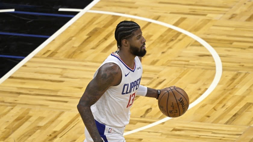 Los Angeles Clippers guard Paul George (13) brings the ball up the court during the first half of an NBA basketball game against the Orlando Magic, Friday, Jan. 29, 2021, in Orlando, Fla. (AP Photo/Phelan M. Ebenhack)