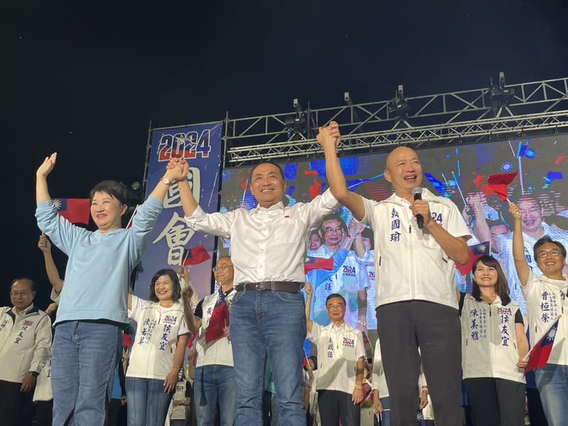 國民黨總統參選人侯友宜（前中）28日晚間在高雄舉辦造勢大會，與台中市長盧秀燕（前左）、前高雄市長韓國瑜（前右）共同登台，漢子、燕子與禿子再合體，攜手展現團結氣勢。（中央社）