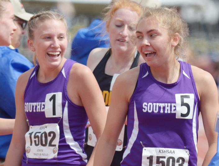 Southeast of Saline’s Jentrie Alderson, left, visits with her teammate Ashley Prochazka after finishing the 3,200-meter run at the Class 3A state track and field meet in Cessna Stadium at Wichita State in 2021.