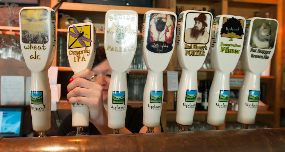 Leah Boruff pours a glass of beer from the tap at the Upland Brewery in this file photo. The popular brewery on 11th Street is expanding this summer. David Snodgress | Herald-Times