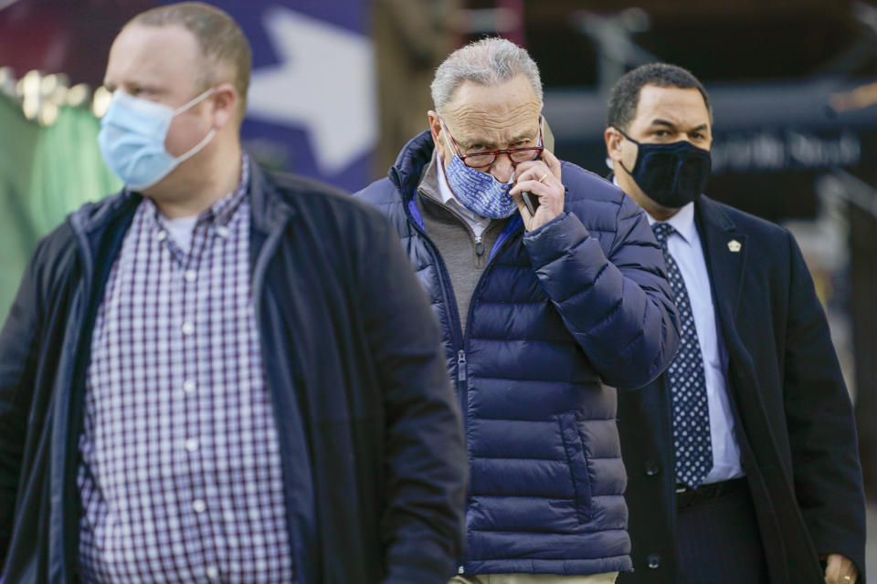 Senate Minority Leader Chuck Schumer, D-N.Y., center, is surrounded by security as he arrives for a news conference, Tuesday, Jan. 12, 2021, in New York. (AP Photo/Mary Altaffer)