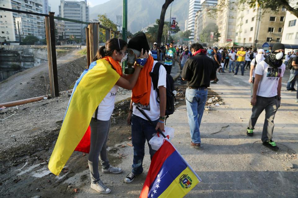 A Couple of demonstrators say farewell to each other, during anti-government protests in Caracas, Venezuela, Tuesday, March 4, 2014. After almost a year after the death of Hugo Chavez, Venezuela has been rocked by weeks of violent protests that the government says have left 18 dead. President Maduro appears ready to use Chavez's almost mythical status to steady his rule as protesters refuse to leave the streets. (AP Photo/Fernando Llano)