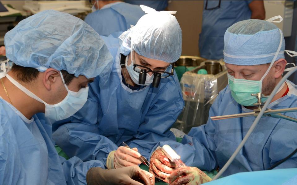 Kleinert Kutz surgeons, Scott Farner, M.D., Elkin J. Galvis, M.D., and Christine M. Kleinert Institute fellow, Raquel Castro, M.D., join nerves and tendons.