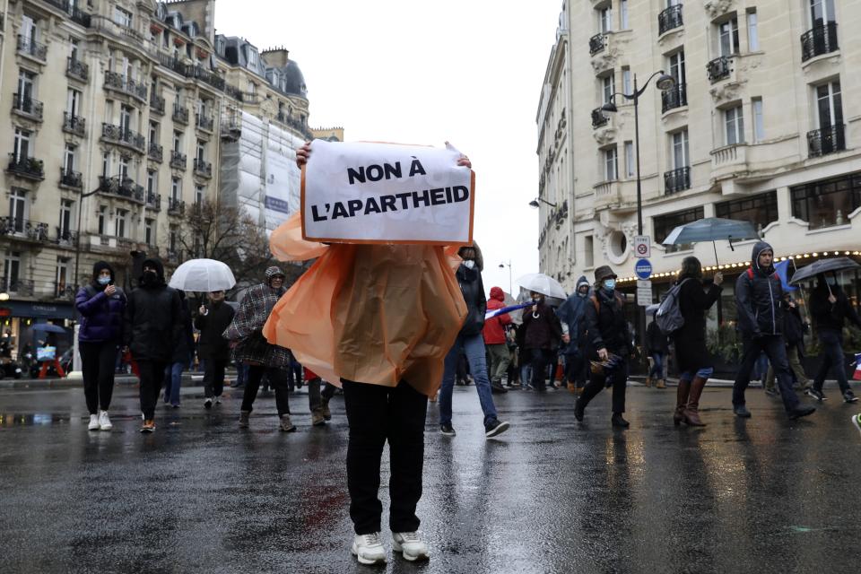 FILE - Demonstrators march in opposition to vaccine pass and vaccinations to protect against COVID-19 in Paris, France, Saturday, Jan. 8, 2022. President Emmanuel Macron has publicly berated the minority of French residents who continue to refuse the vaccine and vowed to restrict their social life by pushing the parliament to pass legislation on a new vaccine pass. The Senate will debate the new vaccine pass bill next week. (AP Photo/Adrienne Surprenant, File)