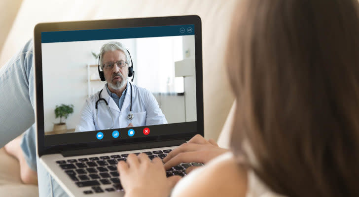 A woman talks to a doctor on her laptop. telehealth stocks