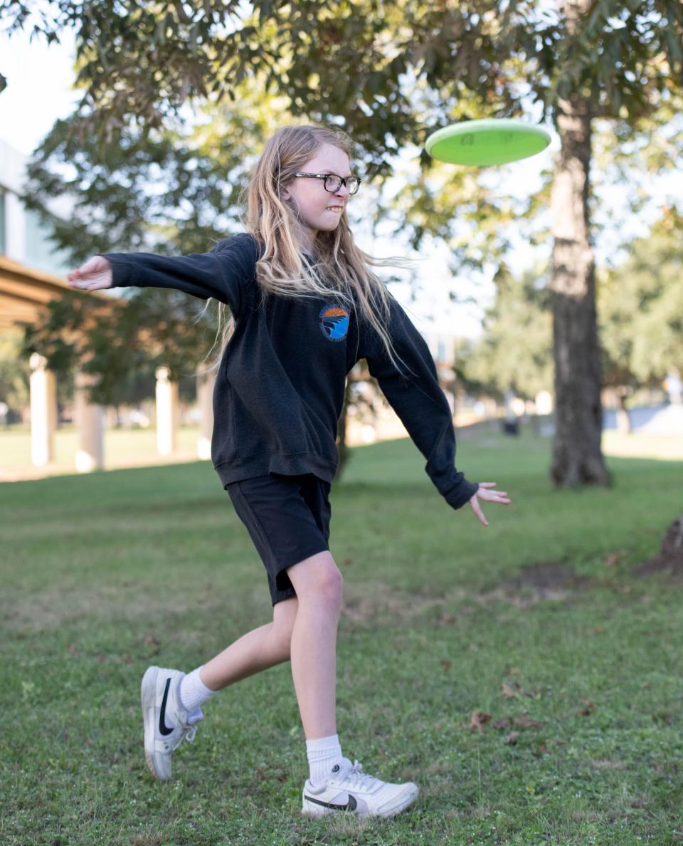 Woods McCue, 12, one of the top junior disc golfers in the country, throws a disc at Hollice T. Williams Park along I-110 in downtown Pensacola on Monday, Oct. 2, 2023.