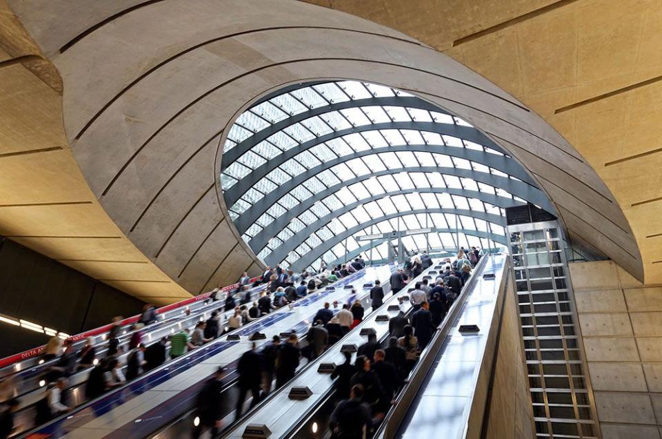  Commuters ascend the exit escalators after arriving at Canary Wharf underground tube station.