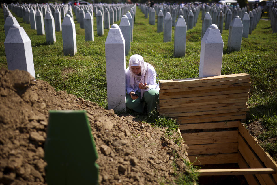 A Bosnian muslim woman prays next to the grave of her relative, victim of the Srebrenica genocide, at the Srebrenica Memorial Centre, in Potocari, Bosnia, Thursday, July 11, 2024. Thousands gather in the eastern Bosnian town of Srebrenica to commemorate the 29th anniversary on Monday of Europe's only acknowledged genocide since World War II. (AP Photo/Armin Durgut)