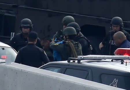 A police SWAT team arrests a man believed to be Daniel Perez, after they stopped his vehicle which was on Amber alert on a freeway exit in Santee, California December 11, 2014. REUTERS/Mike Blake