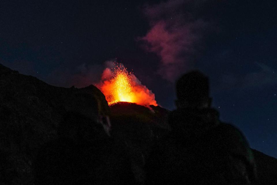 Peoples watch the eruption of the Stromboli volcano, on the Stromboli island, north of Sicily, on September 12, 2022.