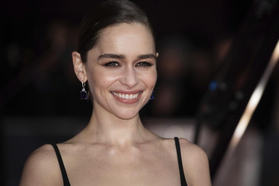 A woman smiling with brown hair pulled back into a bun