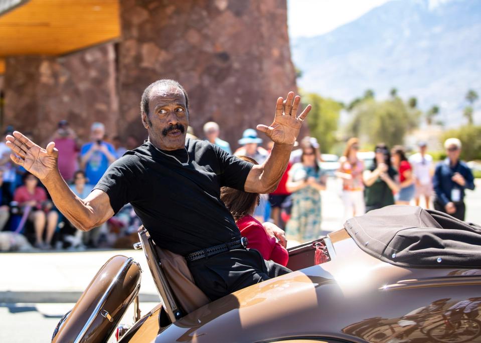 NFL legend Fred "The Hammer" Williams waves to spectators Saturday while riding in a 1938 Chevrolet Master Deluxe during a parade celebrating the city of Palm Springs' 85th birthday.