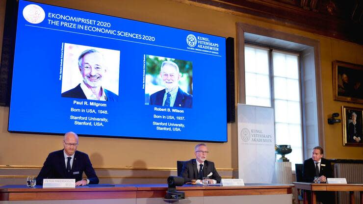 Der Wirtschaftsnobelpreis geht in diesem Jahr an Paul R. Milgrom (l. auf dem Monitor) und Robert B. Wilson. Foto: dpa