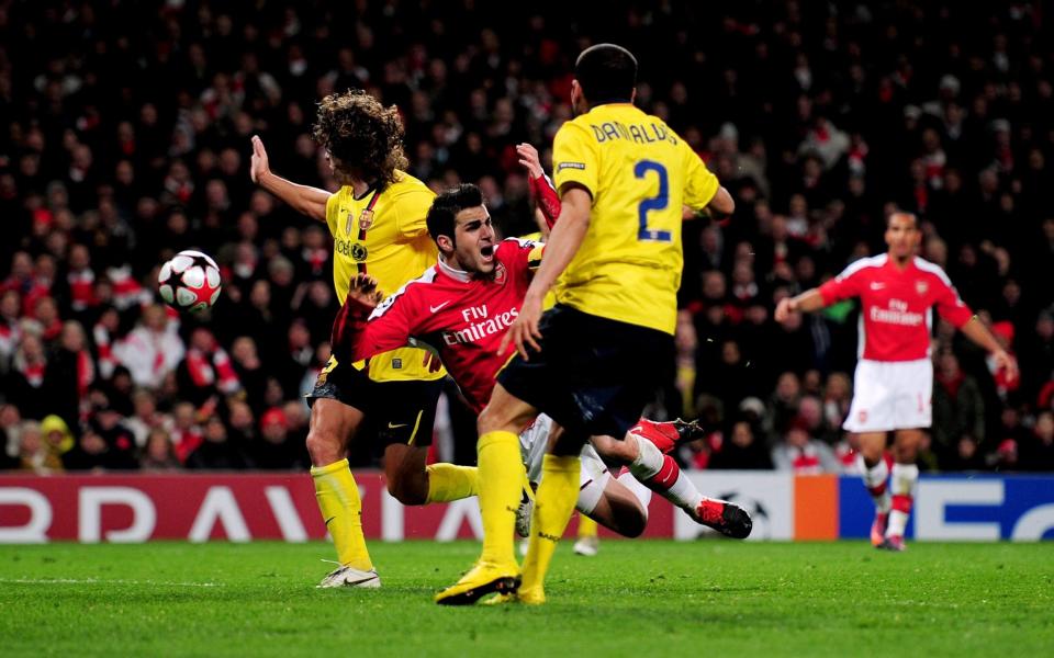 Cesc Fabregas of Arsenal is brought down by Carles Puyol (L) of Barcelona to win a penalty