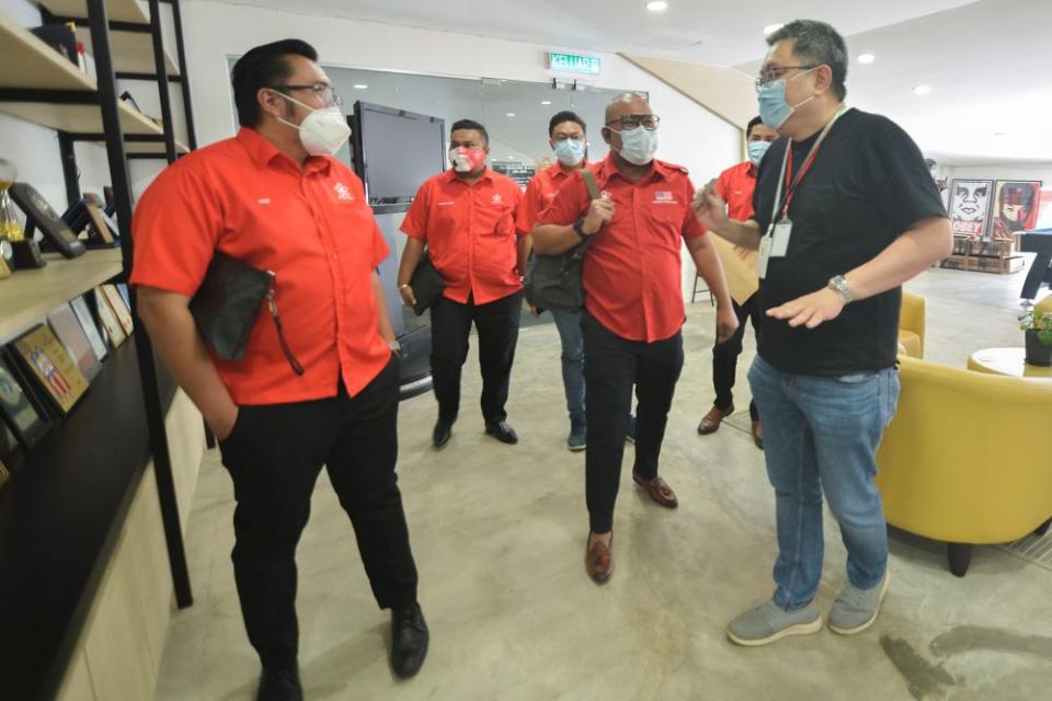 Armada information chief Ashraf Mustaqim Badrul Munir (centre) pays a visit to Malay Mail in Petaling Jaya February 25, 2021. — Picture by Miera Zulyana