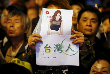 A supporter of Democratic Progressive Party (DPP) Chairperson and presidential candidate Tsai Ing-wen holds up a poster of Taiwanese K-pop singer Chou Tzuyu at their party headquarters as they wait for the results of the general elections in Taipei, Taiwan January 16, 2016. The 16-year-old Taiwan singer with a South Korean girl band inadvertently shot to the top of Taiwan's election agenda on Saturday after she publicly apologized for holding a Taiwan flag, prompting anger in Taiwan as it voted for a new president. China and Taiwan traded accusations after Chou, the only Taiwanese member of Twice, released a video late on Friday in which she said she feels proud to be Chinese and that there is only one China, after she held the flag on a television show. REUTERS/Damir Sagolj