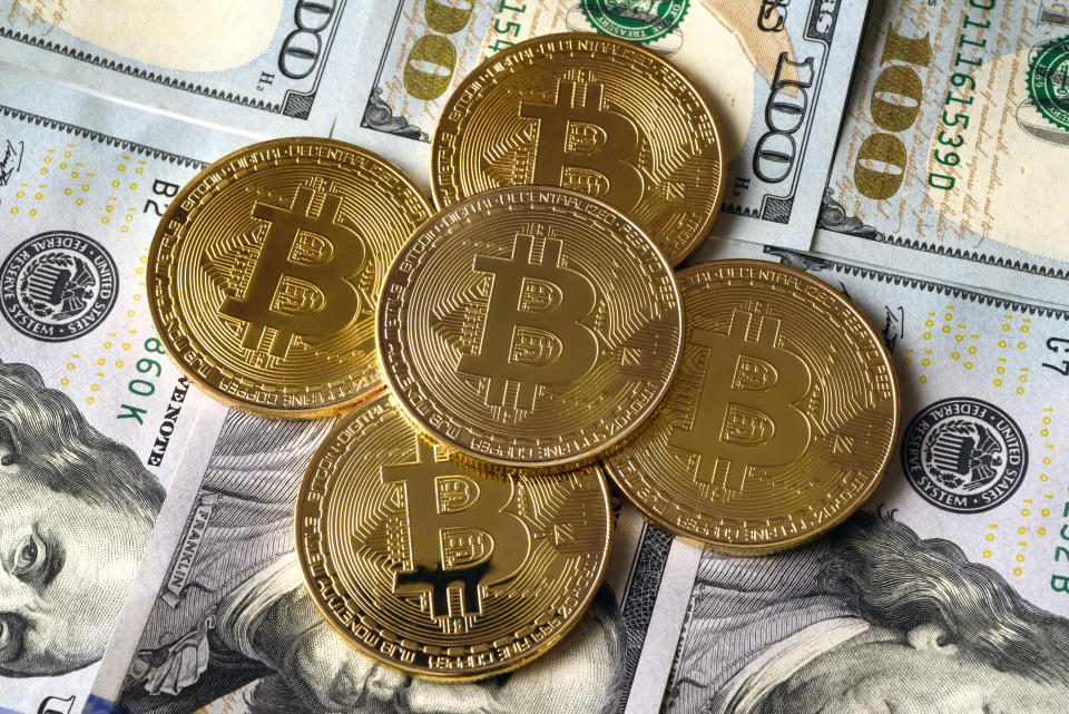 UKRAINE - 2020/12/06: In this photo illustration the Bitcoin cryptocurrency commemorative coins seen on top of the USA Dollars notes. (Photo Illustration by Mykola Tys/SOPA Images/LightRocket via Getty Images)