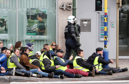 Demonstrators sit on the ground after being detained by police during the "yellow vests" protest against higher fuel prices, in Brussels, Belgium, December 8, 2018. REUTERS/Yves Herman